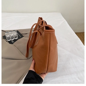 Vue latérale détaillée d'un cabas en cuir marron avec motifs géométriques gaufrés