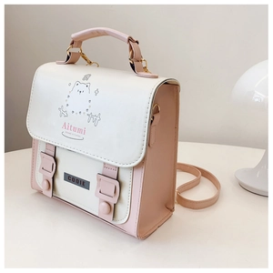 Close-up of pink and cream PU leather handbag featuring cute cat illustration and adjustable strap