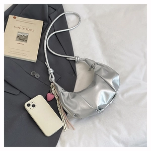 Detail of silver pleated crescent bag with pink heart pendant and stylish shoulder strap