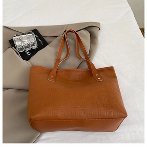 Détail du sac cabas marron en similicuir gaufré avec une bandoulière sophistiquée