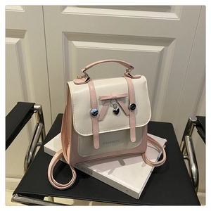 Detail of the pink and white backpack featuring a sweet bow and heart-shaped metal pendant