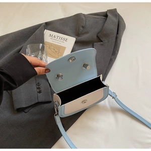 Vue détaillée de l'intérieur du sac selle bleu et beige avec fermoirs magnétiques