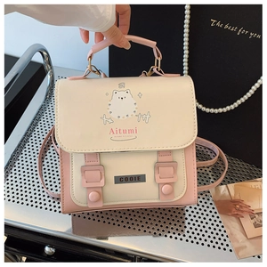 Detailed view of the pink and cream school bag with cartoon dog print and strap accents