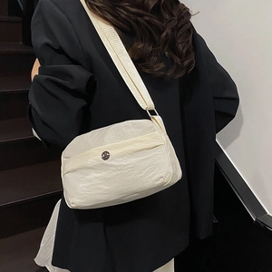 Minimalist beige crossbody tote bag with wide shoulder strap and textured fabric