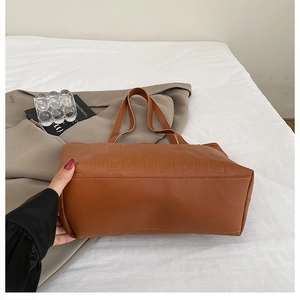 Détail du sac fourre-tout caramel gaufré avec motifs et longues bandoulières