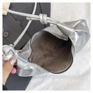 Detail view of silver crescent bag with wide interior, fabric lining and zipper closure
