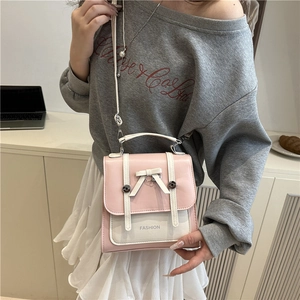 Chic pink and white leather crossbody bag with bow detail and adjustable shoulder strap
