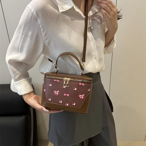 Brown box crossbody bag with cherry prints and top handle for stylish women