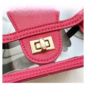 Detail of rose pink pebbled leather bag with a gold rectangular metal lock and PVC material