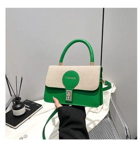 Dettaglio di borsa a tracolla in pelle verde e paglia con fibbia metallica moda