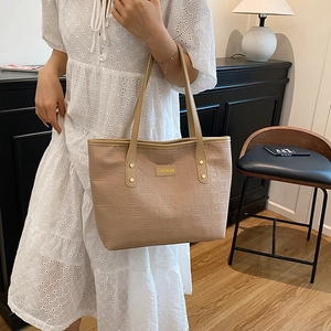 Grand sac cabas beige gaufré avec plaque dorée et fine bandoulière pour femme élégante