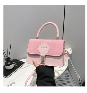 Dettaglio borsa a tracolla rosa in pelle con patta intrecciata e chiusura in metallo oro