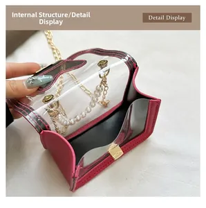 Detail display of mini transparent PVC crossbody bag with gold hardware and pearl handle