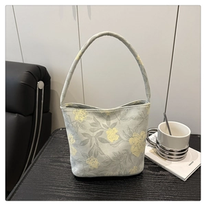 Détail d'un sac seau floral avec poignée circulaire sur une table texturée sombre