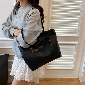 Sac cabas noir avec gaufrage géométrique et logo en métal doré pour le quotidien