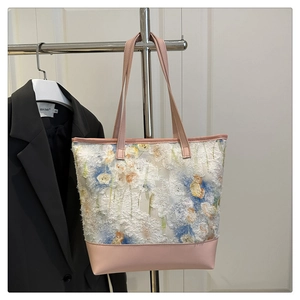 Detail view of stylish tote bag featuring 3D floral jacquard and pink leather trim