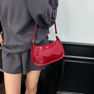 Fashionable bright red patent leather shoulder bag with golden metallic buckle