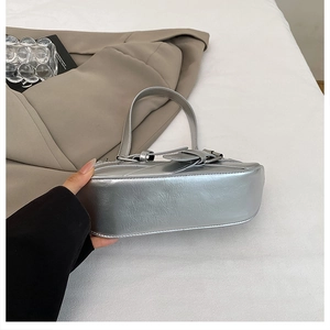 Detail view of silver Y2K shoulder bag featuring metallic wrinkled leather and buckle