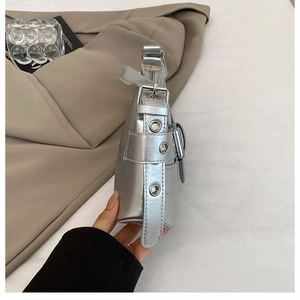 Detail of silver metallic shoulder bag showing multiple eyelet straps and buckles