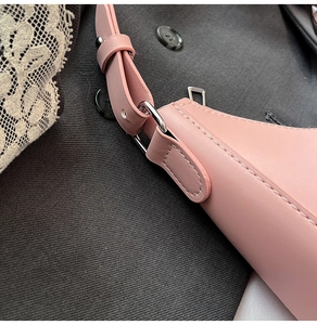 Detail of pink faux leather bag showing white contrast stitching and adjustable strap buckle