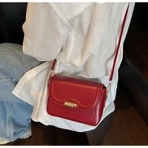 Details einer roten Vintage-Lederschultertasche mit eleganter goldener Metallschnalle
