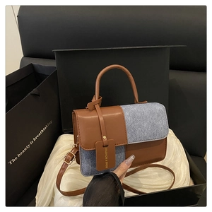 Detail of vintage patchwork handbag in brown leather and blue denim with fashion tag