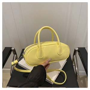 Minimalistische leuchtend gelbe pillenförmige Handtasche mit Doppelgriffen und Schultergurt