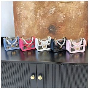 Detail of colorful mini transparent PVC bags with pearl handles and gold turn-lock clasps