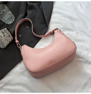 Detailed view of pink moon bag with lychee grain texture on a white linen surface