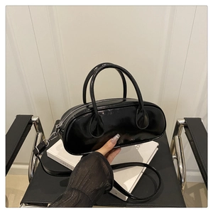 Detaillierte Nahaufnahme einer schwarzen Lackleder-Baguette-Tasche mit silbernen Beschlägen
