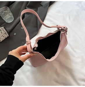 Detail of light pink half-moon shoulder bag showing interior space and silver zipper