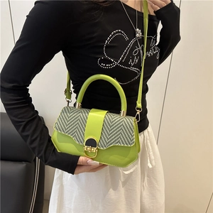 Green leather crossbody bag with black and white pattern flap shown on a model