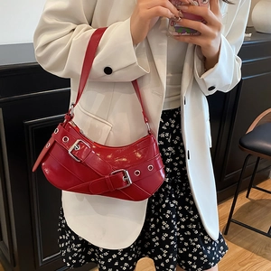 Glossy red faux leather hobo bag with belt buckles and metallic eyelet details