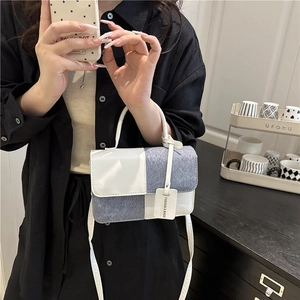 Chic color-block handbag in white leather and blue denim with a vintage top handle design