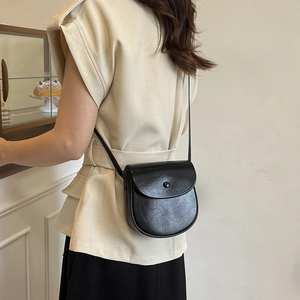 Chic black saddle crossbody bag for women with a sleek semi-circle design and round buckle