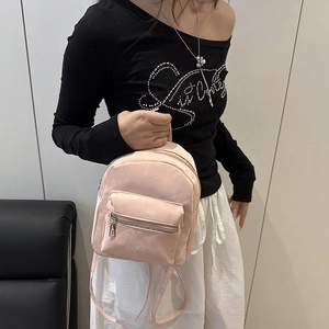 Minimalist light pink mini backpack in faux suede being worn by a model in casual style