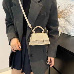 Mini beige fabric handbag with textured surface and shoulder strap for elegant styling