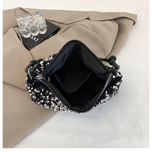 Detail of sequin handbag featuring metal zipper closure and black fabric inner pocket