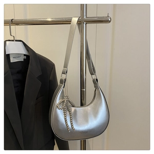 Détail du sac hobo argenté avec gaufrage Fashion et breloque papillon perlé