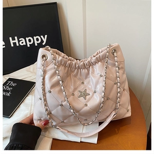 Detail view of light pink quilted patent leather shoulder bag with star-shaped jewel charm