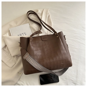 Detail of dark brown tote bag featuring crocodile pattern and ethnic style wide strap