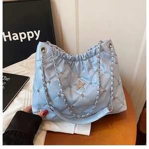 Detailed shot of quilted pattern on light blue chain bag with star pendant