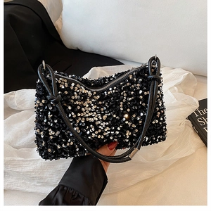 Close-up of black and silver sequins on stylish shoulder bag with leather knot strap