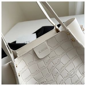 Close-up of white crocodile pattern tote bag with MS.HUIXIBAG logo and metal rivets
