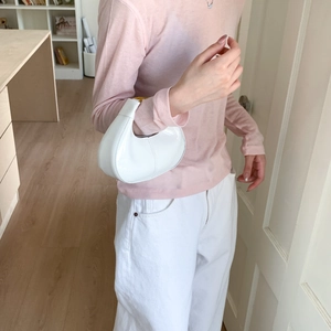 Détail du sac croissant en cuir verni blanc avec garnitures dorées et coutures