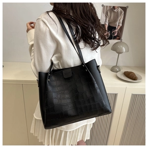 Detail view of black crocodile pattern tote bag with wide strap and smooth side stitching