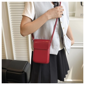 Close-up of a red leather mobile phone crossbody bag with flap cover and shoulder strap
