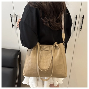 Detail of khaki crocodile pattern tote bag with modern geometric wide shoulder strap