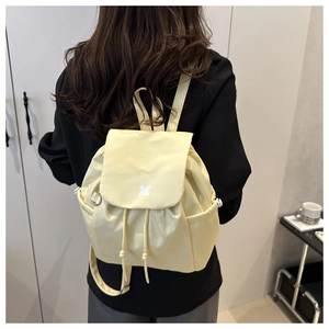 Rear view of a light yellow checkered backpack on model showing casual college style