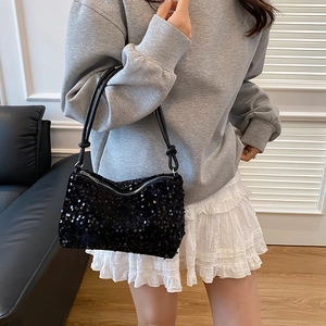 Fashionable black sequin shoulder bag with leather strap shown worn by a model